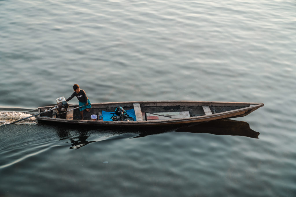 Fischerboote fahren am Frachtschiff auf dem Amazonasvorbei