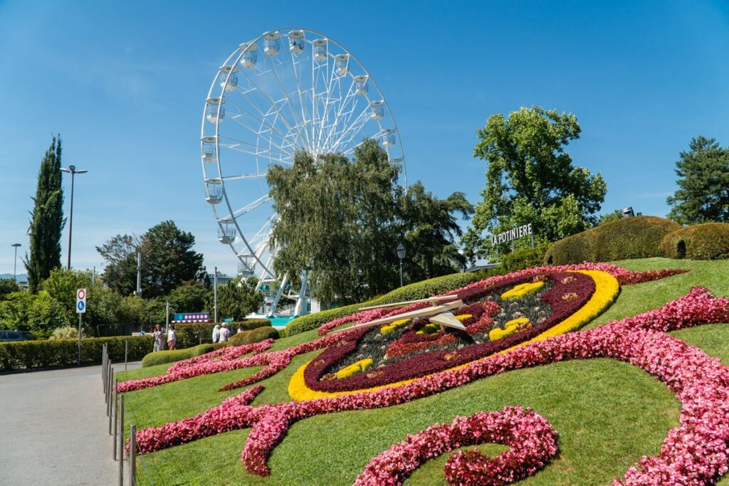 Eine kostenlose Sehenswürdigkeit für ein Tag in Genf: Die Blumenuhr in Genf mit dem Riesenrad im Hintergrund.