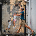 Tobi spielt Basketball an einem Street Art in George Town