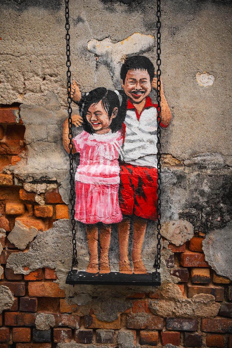 Kinder auf einer Schaukel als Street Art